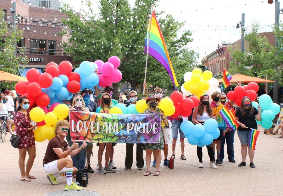 A group of marchers hold up a Loveland Pride banner and rainbow flags in Old Town Square before the start of the second annual Northern Colorado Pride March July 17, 2020. (Serena Bettis | The Collegian)