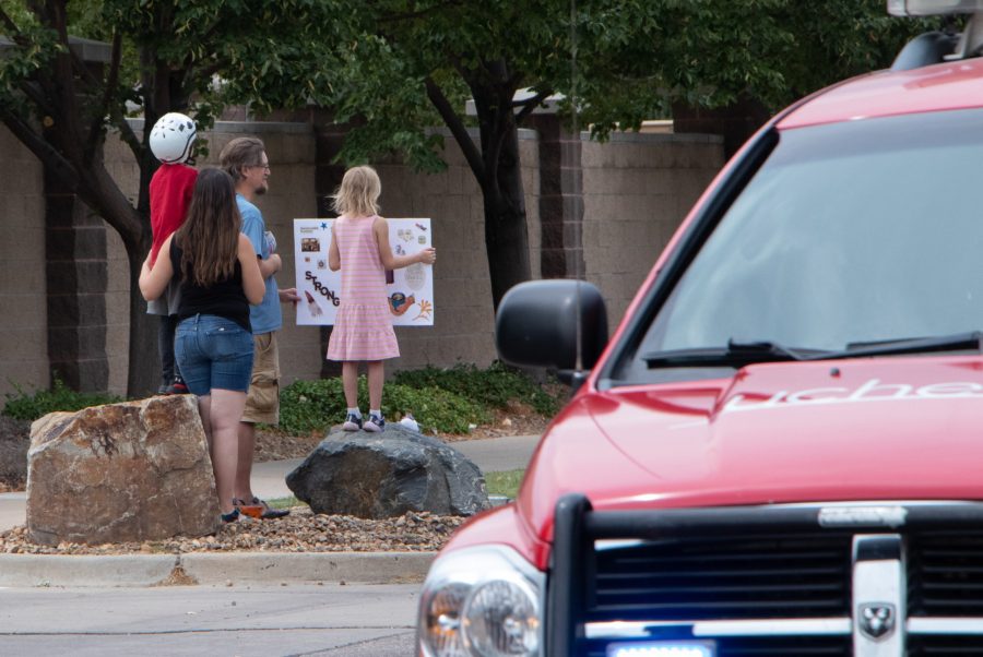 A family watches the memorial procession of emergency service vehicles honoring Larimer County Department of Natural Resources Ranger, veteran and Colorado State University alum Brendan Unitt Aug. 28. Unitt died at Hoorsetooth Reservoir while on duty Aug. 20. Cause of death is currently under investigation. (Anna von Pechmann | The Collegian) 