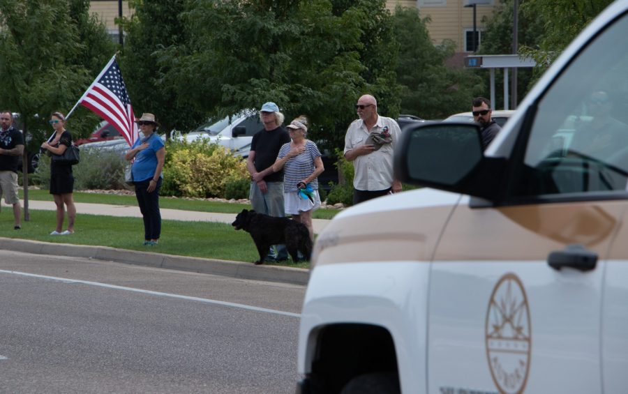 Community members hold their hands to their hearts as they watch the memorial procession for Larimer County Department of Natural Resources Ranger, veteran and Colorado State University alum Brendan Unitt Aug. 28. (Anna von Pechmann | The Collegian) 
