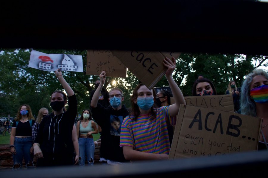 Protesters hold up signs in front of the entrance to the Colorado State University Police Department building Aug. 26. The protest was organized in response to a police officer shooting Jacob Blake in Kenosha, Wisconsin, Aug. 23. (Anna von Pechmann | The Collegian) 
