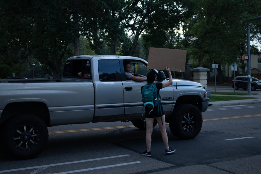 Protestor speaks to a man in a truck while marching from the Colorado State University Police Department building back to The Oval Aug. 26. The protest was organized in response to the death of Jacob Blake, who was shot by a police officer in Kenosha, Wisconsin Aug. 23. (Anna von Pechmann | The Collegian) 