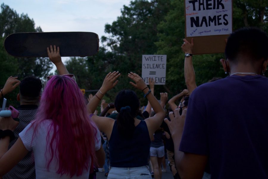 Protestors put their hands up during a chant as they march down W Laurel St. Aug. 26. The protest was organized in response to the death of Jacob Blake, who was shot by a police officer in Kenosha, Wisconsin Aug. 23. (Anna von Pechmann | The Collegian) 