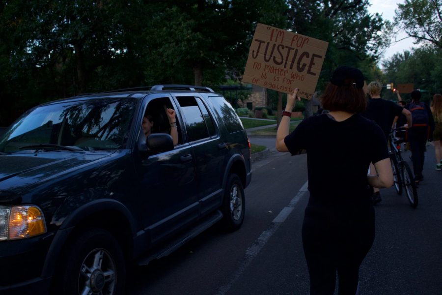 Protestors march down W Laurel St. as driver holds a fist up in solidarity Aug. 26. The protest was organized in response to the death of Jacob Blake, who was shot by a police officer in Kenosha, Wisconsin Aug. 23. (Anna von Pechmann | The Collegian) 