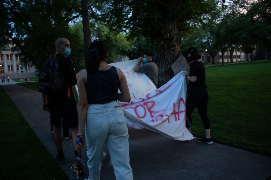 Protestors walk banners towards the Colorado State University Administration Building to place them on the steps after the march Aug. 26. The protest was organized in response to the death of Jacob Blake, who was shot by a police officer in Kenosha, Wisconsin Aug. 23. (Anna von Pechmann | The Collegian) 