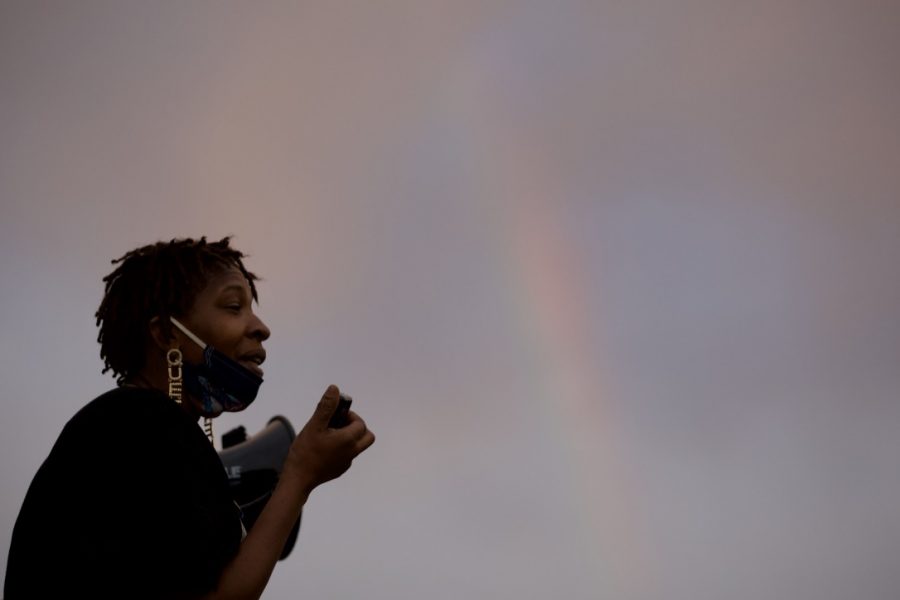 Queen speaks in front of protesters as a rainbow forms in the distance. Queen talked about being a Black mother and her fear for her boys because they could be shot based solely on the color of their skin. (Ryan Schmidt | The Collegian)