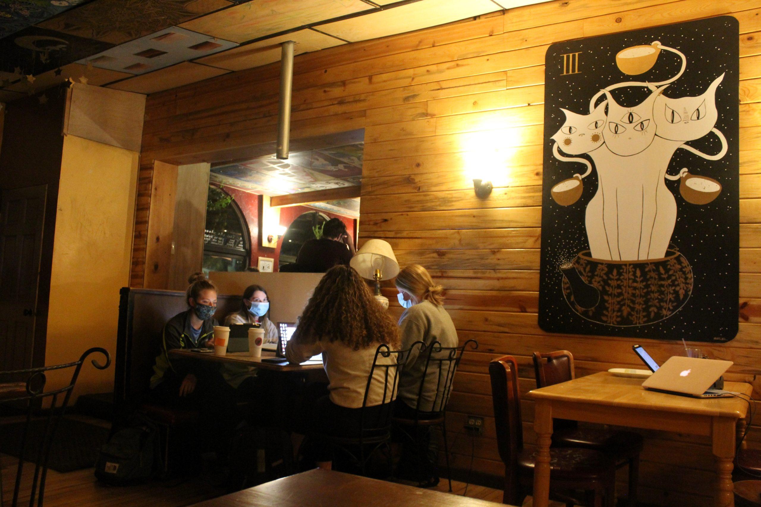 four girls sit at a table studying at the Alleycat