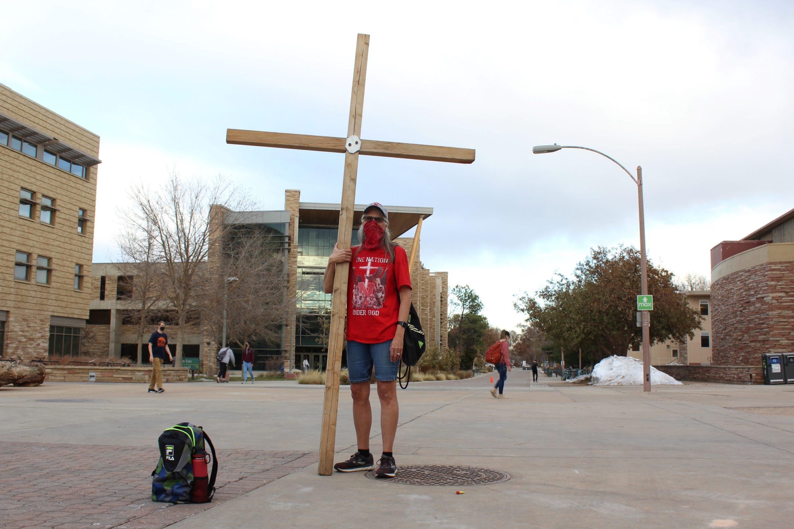 woman with cross stands on the plaza