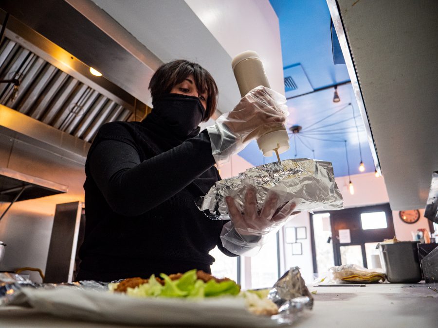 Denise Hakim, the owner of YumYum Social Club, prepares a falafel sandwich for one of her daily customers, Mar. 4. The grand reopening of the 30 years old family business is to “make the past mistakes right again and approach the business with a different attitude,” Hakim said. (Tri Duong | The Collegian)