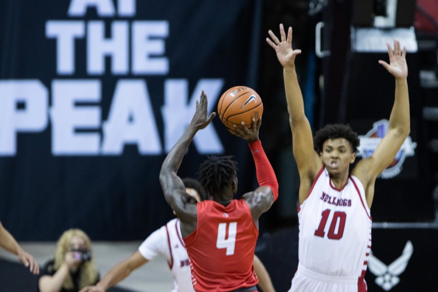 Emmanuel Kuac (4) takes a step back shot over Orlando Robinson (10), during the Air Force Reserve Mountain West men's basketball tournament in Las Vegas.  (Devin Cornelius | Cornelius)