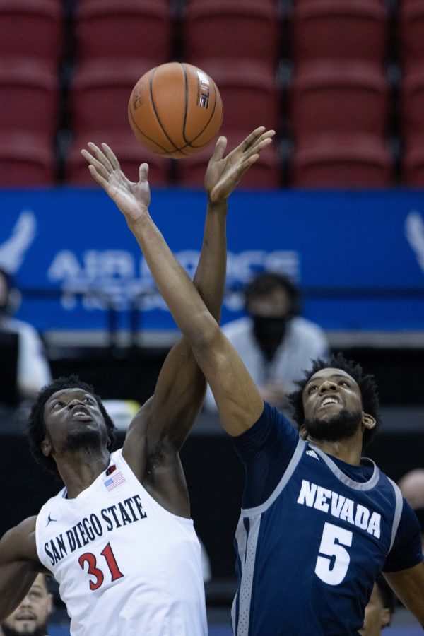 Nathan Mensah (31) and Warren Washington (5) reach for the ball at tip time for San Diego State University and the University of Nevada game Mar. 12, during the Air Force Reserve men's basketball tournament in Las Vegas Nevada. SDSU wins 77-70. (Devin Cornelius | Collegian) 