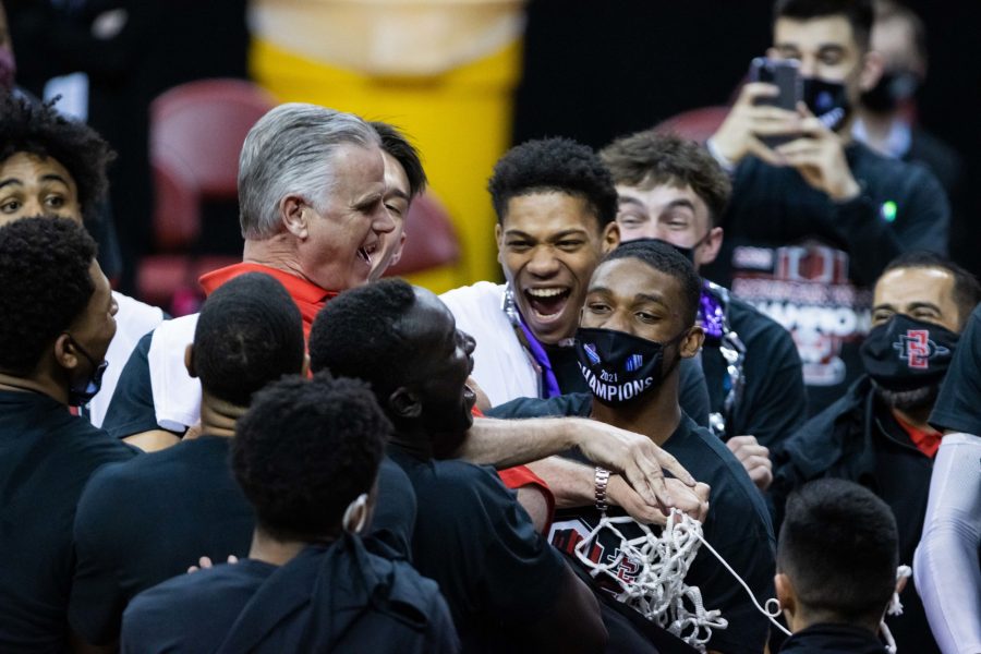 The San Diego State Aztecs team catch their coach Brian Dutcher after SDSU defeats the Utah State Aggies in the Air Force Reserve Mountain West tournament final and advance to the NCAA tournament. (Devin Cornelius | The Collegian) 