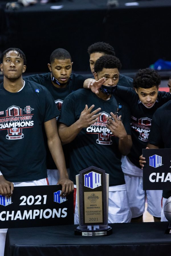 Matt Mitchell (11) poses with his teammates and the Mountain West men's basketball trophy after his team defeats Utah State University in the Air Force Reserve Mountain West men's basketball tournament. (Devin Cornelius | The Collegian) 