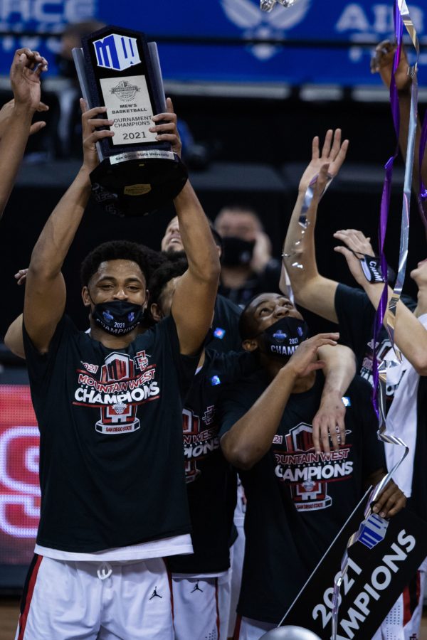 Matt Mitchell (11) holds up the Mountain West men's basketball trophy after his team defeats Utah State University in the Air Force Reserve Mountain West men's basketball tournament. (Devin Cornelius | The Collegian) 