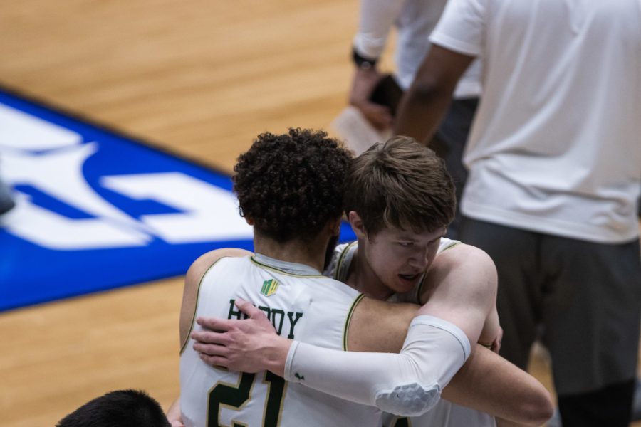 David Roddy (21) and Adam Thistlewood (31) hug after Colorado State University defeats North Carolina State University in the National Invitation Tournament quarterfinal game in Fresco, Texas the Comerica Center March 25. Colorado State beat NC State 65-61. (Devin Cornelius | The Collegian)