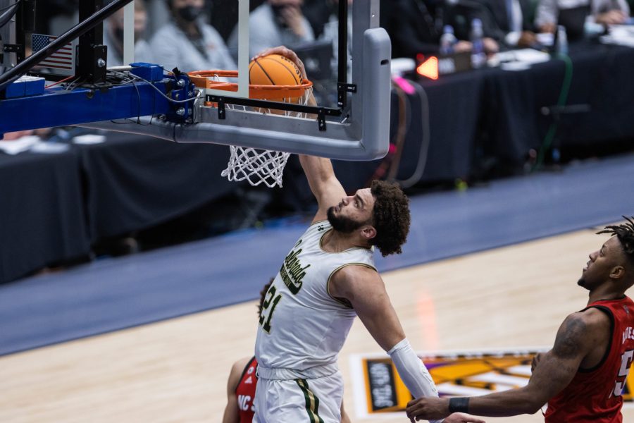 David Roddy (21) dunks the ball after driving past a defender, during Colorado State University’s basketball game versus North Carolina State University at the National Invitation Tournament in Fresco, Texas in the Comerica Center. Colorado State beat NC State 65-61 March 25. (Devin Cornelius | The Collegian)
