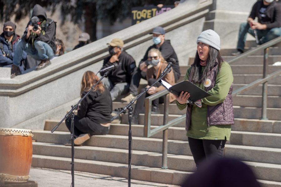 A woman sings at a protest outside the Colorado State Capitol March 27. The protest featured speeches, poetry, and music from the Asian-American and Pacific Islander community. (Michael Marquardt | The Collegian)