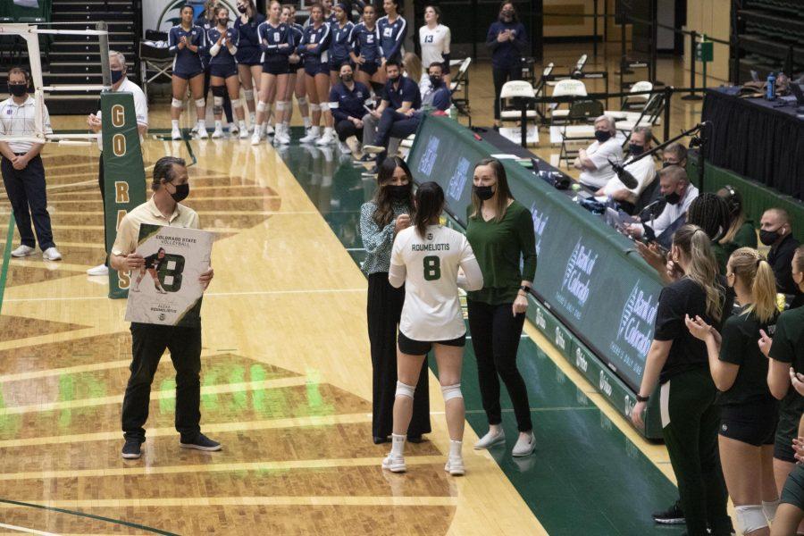 Colorado State University volleyball Associate Head Coach Emily Kohan (left) and Assistant Coach Adrianna Blackman (right) give senior Alexa Roumeliotis a bouquet of flowers as Head Coach Tom Hilbert waits to give her a poster before the last home game of the season, March 27. (Anna von Pechmann | The Collegian) 