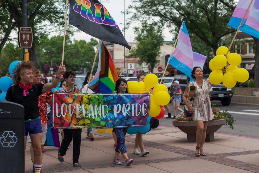 Demonstrators carry banners and flags in the NoCo Pride March July 16. The march featured a line of approximately 600 demonstrators walking down College Avenue which stretched for five and a half blocks. (Michael Marquardt | The Collegian)