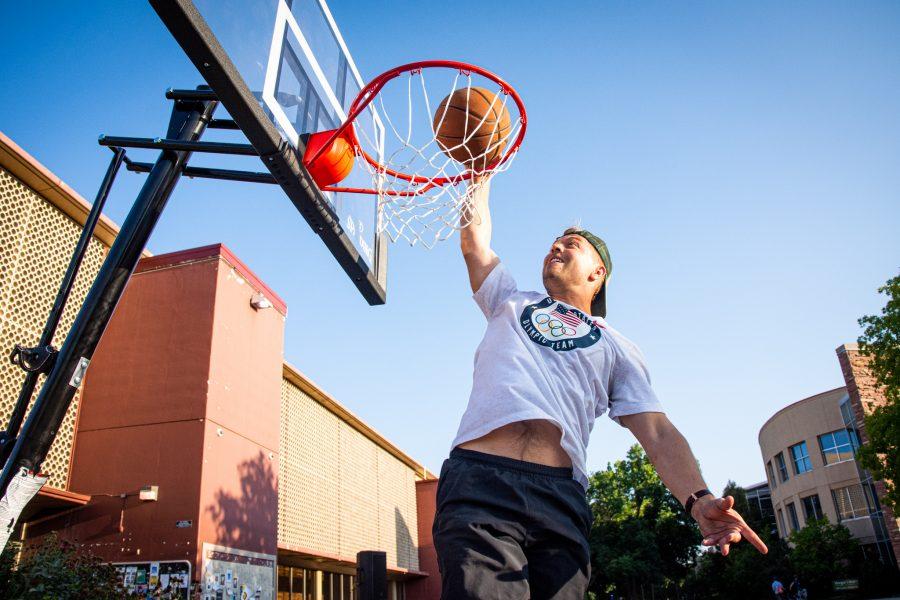 Matt Smith, campus staff for Colorado State University Student Mobilization, dunks a basketball by the Clark Building Aug. 25.
