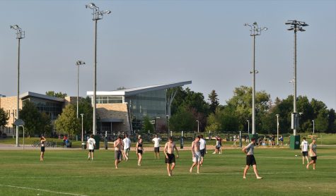 A group of students play a game of ultimate frisbee near the Student Recreation Center