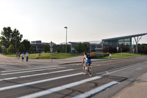 A cyclist passes in front of the Student Recreation Center Aug. 28, 2021. All full-time Colorado State University students have unlimited free access to gym equipment, personal training opportunities, a pool and outdoor equipment rentals.