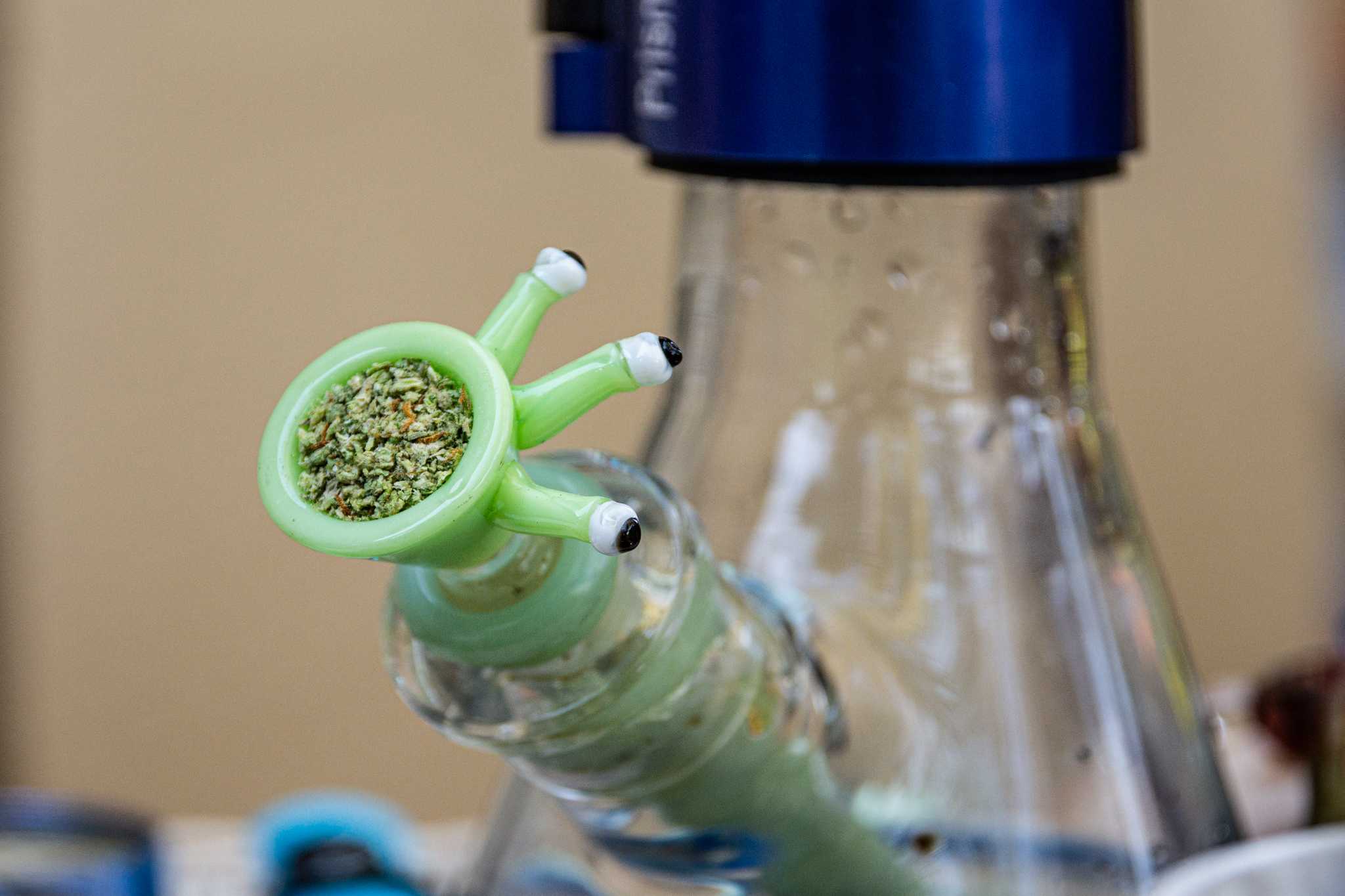 A bowl of cannabis sits on a bong