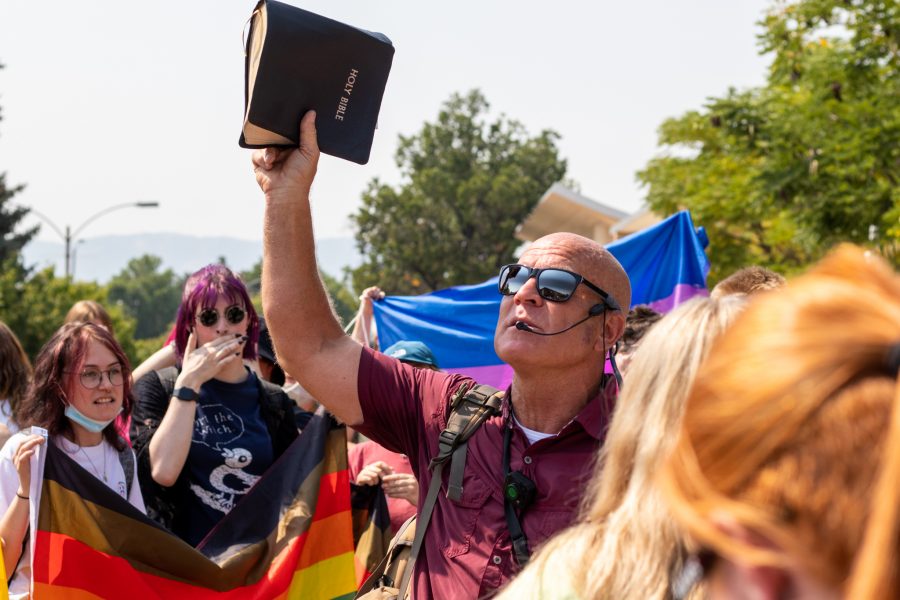 A preacher sings from the Bible while surrounded by students on The Plaza Sept. 8. “They have no understanding that, ultimately, what are the two commandments we have to have? Love thy god with all thy heart and all thy soul, and love thy neighbor,” said Shawn Bowie, a bystander.