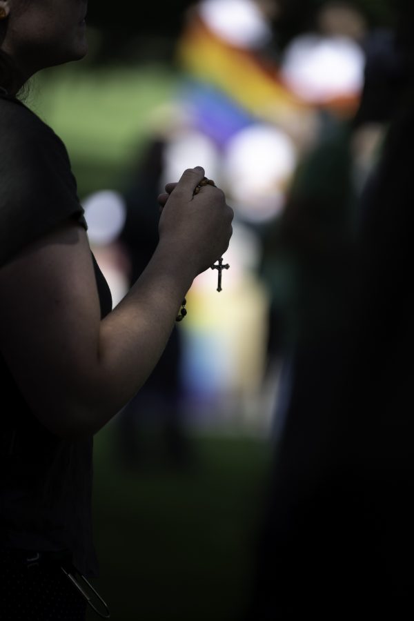 A person holds a rosery with pride flags in the background at a Call Out Colorado State University protest. Call Out CSU is a response to Colorado State University’s handling of two preachers who were preaching controversial topics Sept. 17. (Garrett Mogel | The Collegian)
