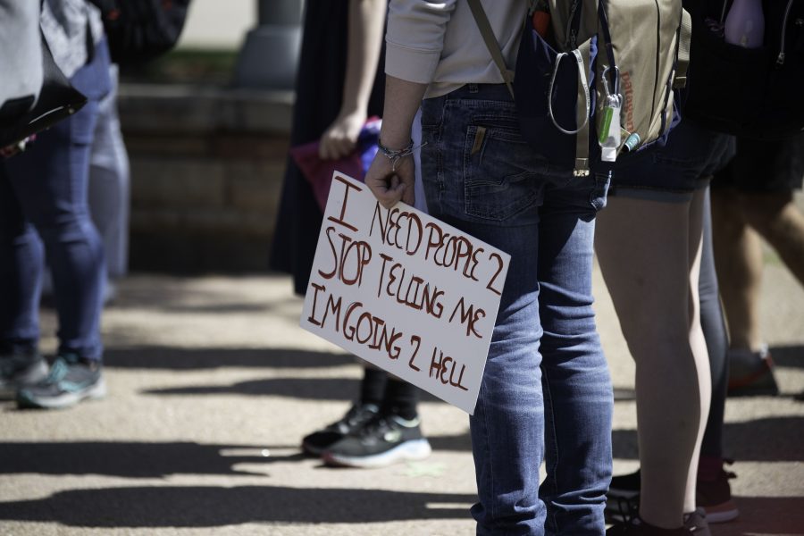 Protestor holds sign at the Plaza for Call Out Colorado State University. (Garrett Mogel | The Collegian)