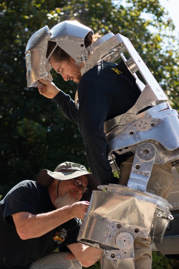 Robin Edmiston carefully assembles the Mark I Iron Man suit around his son, the creator, Dylan Edmiston, Sept. 19. This father-son duo can assemble the suit in under 40 minutes. (Grayson Reed | The Collegian)