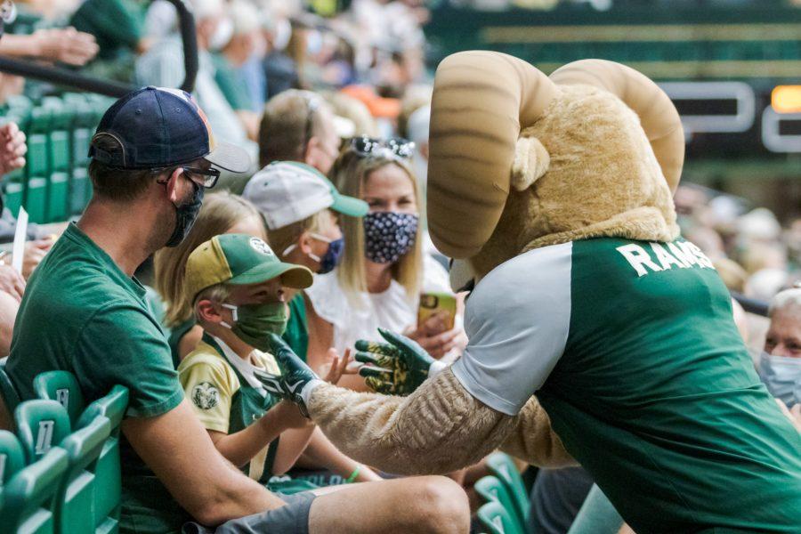 Colorado State University mascot CAM the Ram high-fives a young fan during the volleyball game against the University of Colorado Boulder Sept. 18. The University of Colorado Boulder won 3-0.