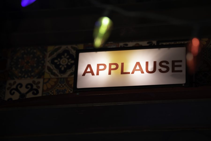 An illuminated "Applause" sign hangs above a hallway in the Lyric in Fort Collins Colorado. 