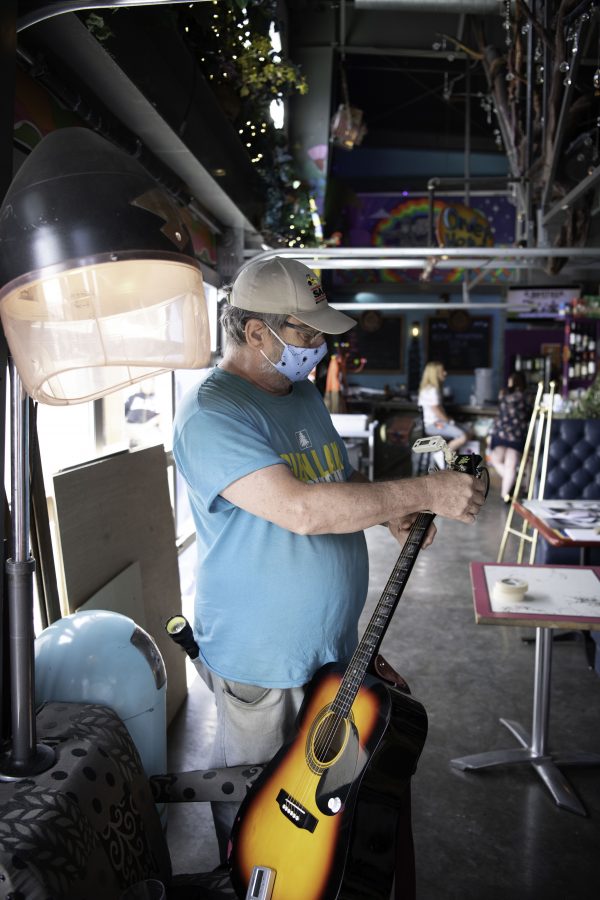A persons tunes a guitar in the common are of the Lyric in Fort Collins Colorado. Part of the Horsetooth Int'l Film Festival was also live music. The Film Festival took place from September 8th to the 12th 2021.  