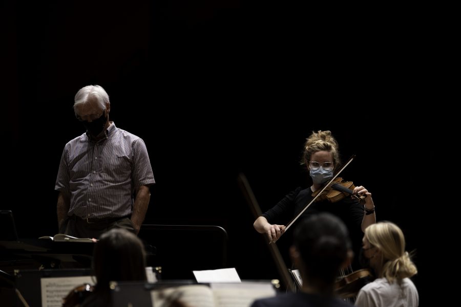 Concertmaster Annie Smith stands beside Wesley Kenney after a short break to lead in tuning instruments. 