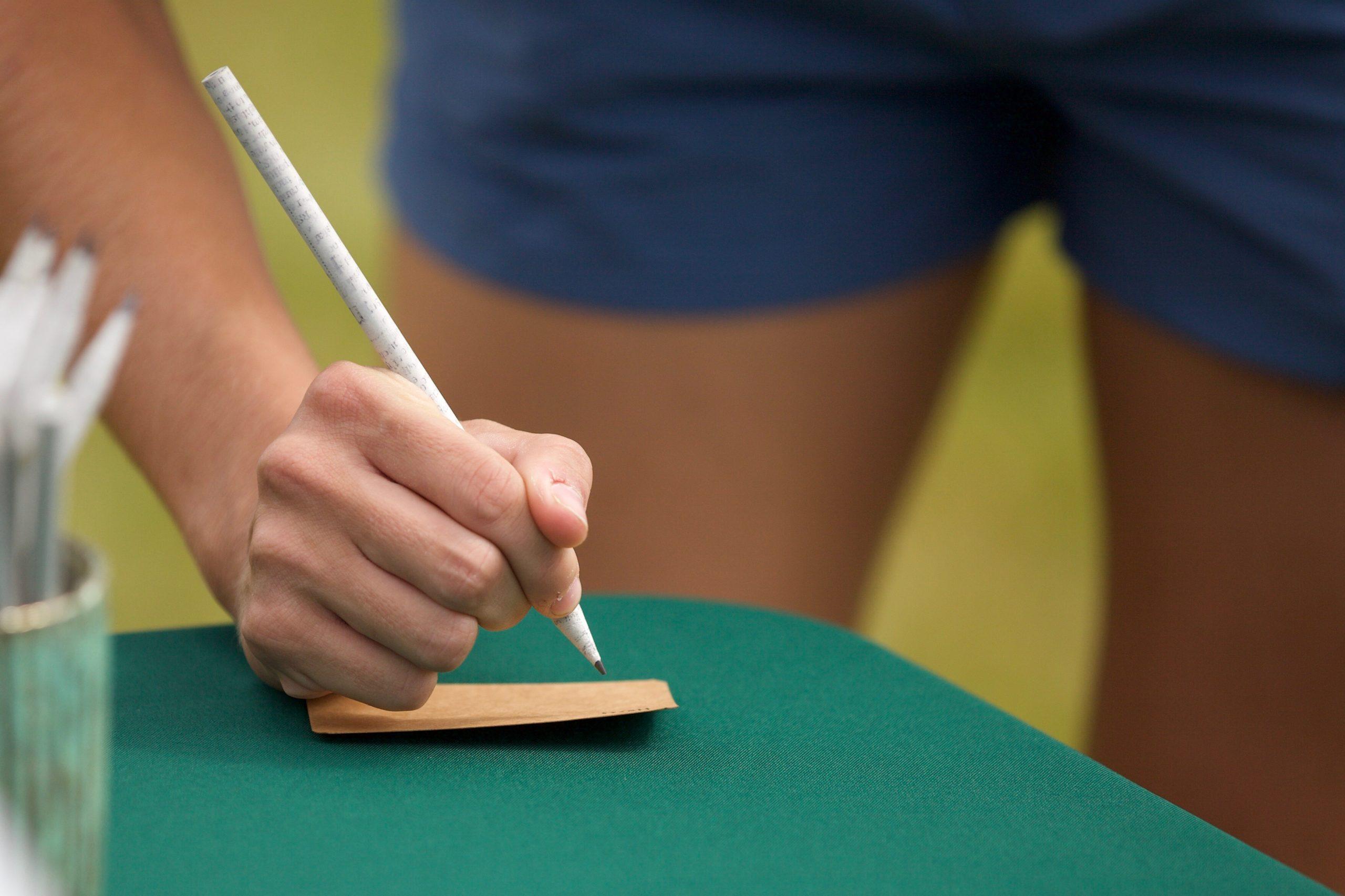 a person writes on a piece of paper