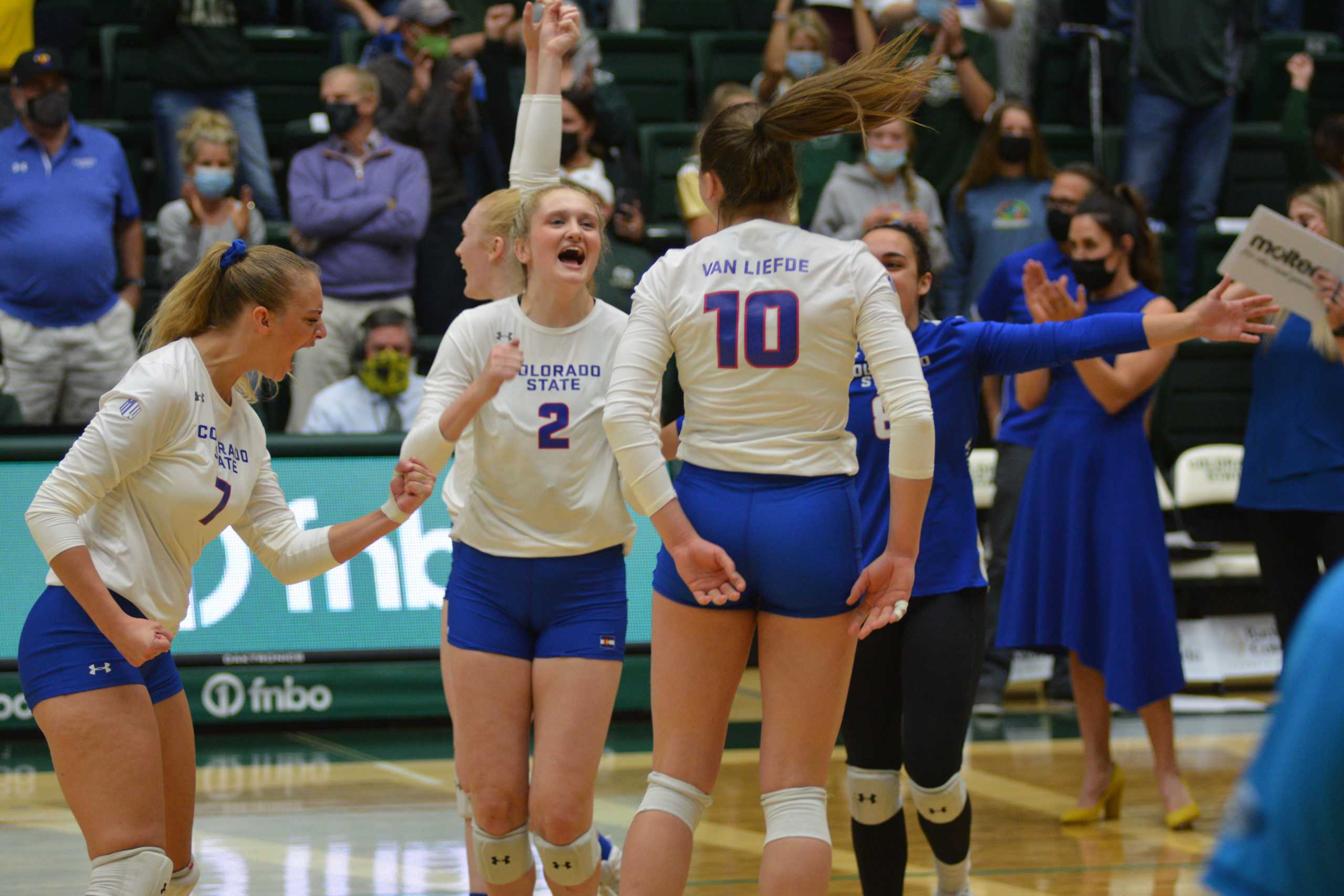 Colorado State volleyball team members celebrate a decision by the referees to award a point to the team
