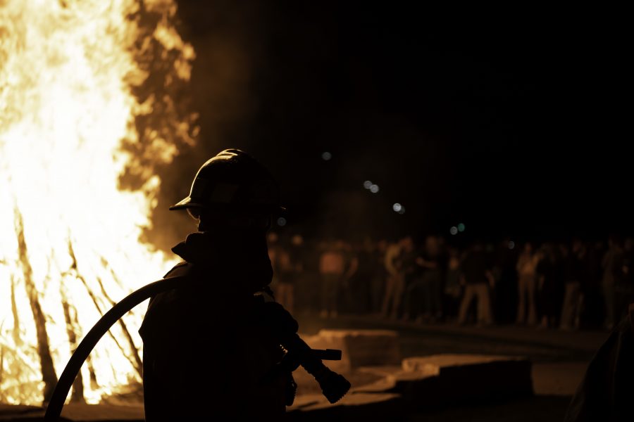 A firefighter stands ready at the Colorado State University homecoming bonfire Oct. 8. (Garrett Mogel | The Collegian)
