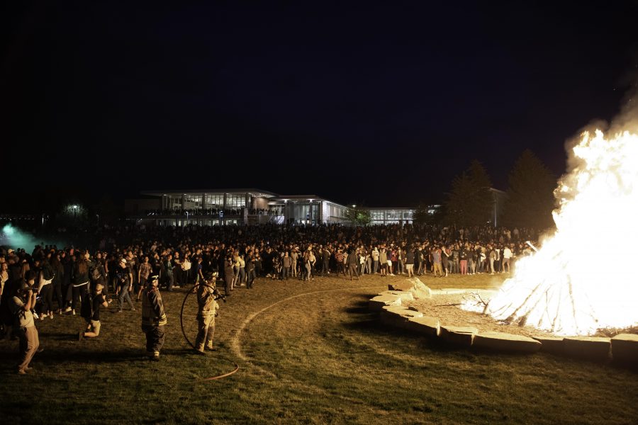 People back away from the intense heat of the homecoming bonfire outside the Colorado State University Lory Student Center Oct. 8. (Garrett Mogel | The Collegian)