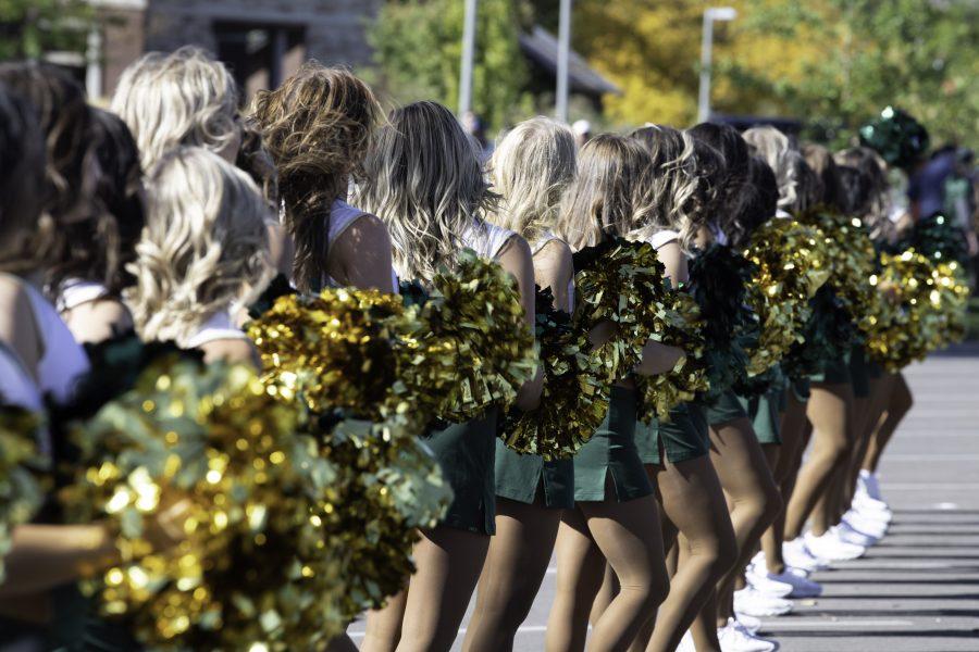 The Colorado State University Cheer team lines the edge of the procession to Canvas Stadium Oct. 9. (Garrett Mogel | The Collegian)