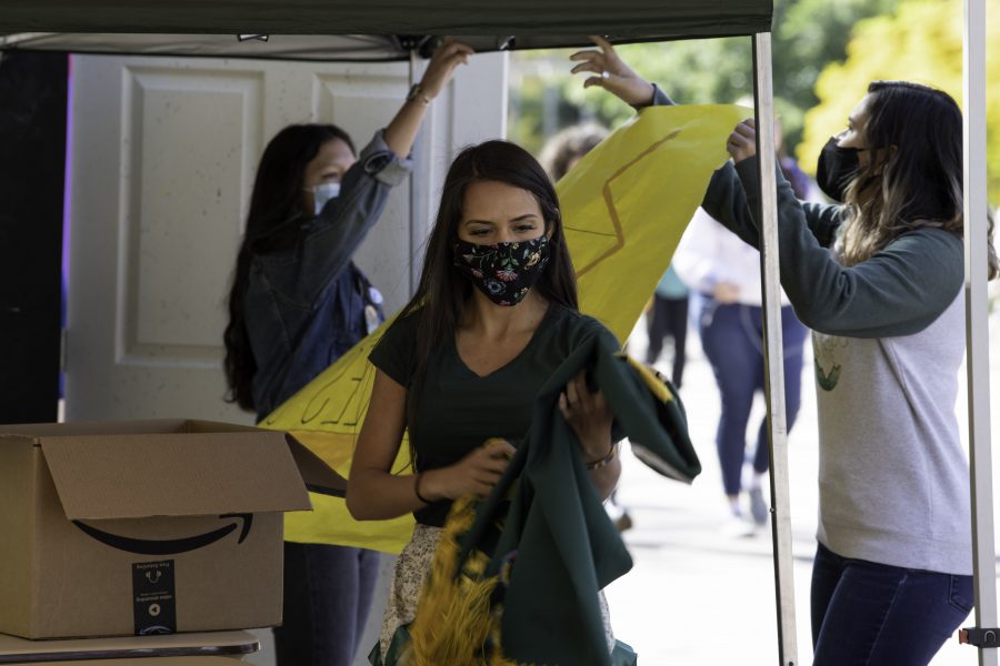 Danita Ordaz, of the Jicarilla Apache and Machico tribes, unfolds a handmade shawl for the Indigenous Peoples’ Day booth setup on the Colorado State University Plaza. Ordaz stated, “We really have reclaimed this holiday in positive reframing where we just want to celebrate our existence.” Oct. 11. (Garrett Mogel | The Collegian)