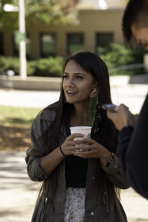 Danita Ordaz stands on the Colorado State University Plaza holding a cup of hot chocolate provided by the Indigenous Peoples’ Day booth Oct. 11. (Garrett Mogel | The Collegian)
