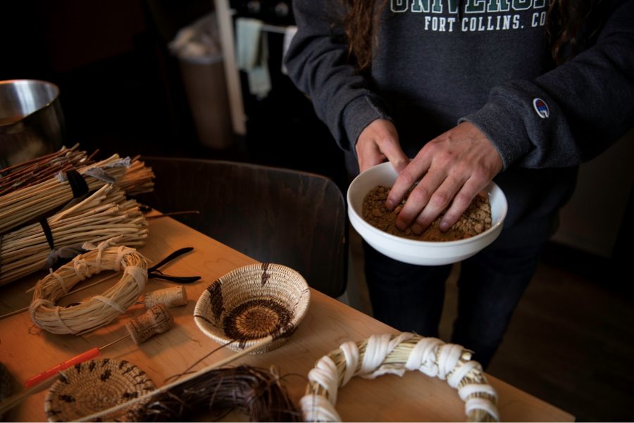 Stephen Young of the Mountain Maidu tribe holds a bowl of ground acorn that he uses to dye a certain material in his apartment on Colorado State University's campus Oct. 12. The acorn is cooked in baskets and mixed with other materials to dye Bracken fern black. “When you soak a basket properly, first the stitches will expand, the foundation will expand and you can put water in it and it wont leak," Young said. "(This) is how we're able to cook in baskets as well.” (Garrett Mogel | The Collegian)
