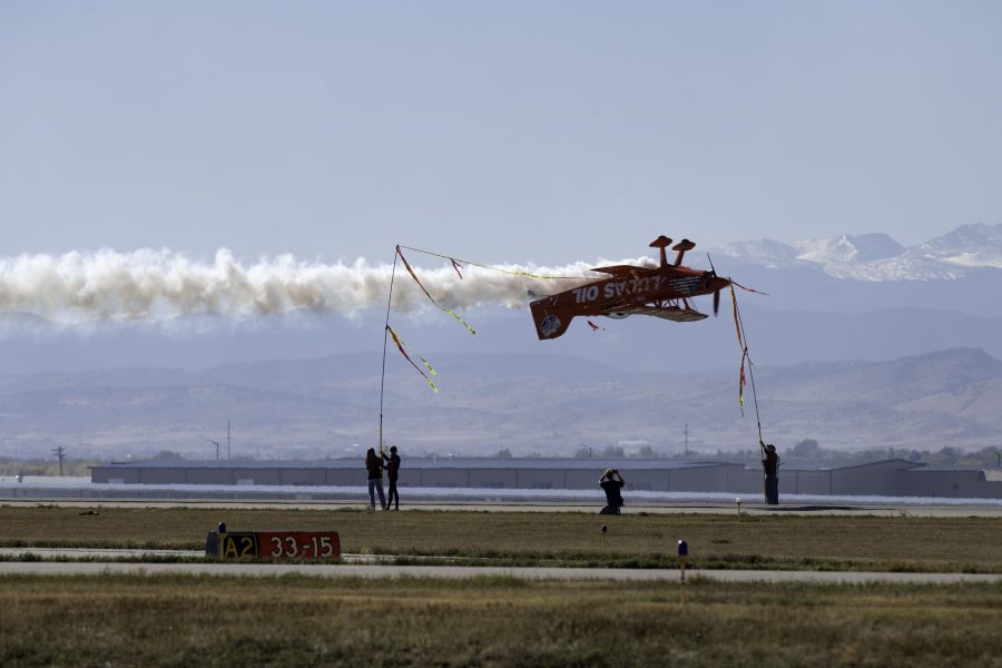 Michael Wiskus flies an aerobatic performance at the Great Colorado Air Show in a Super Stinker S-1-11B biplane and cuts a ribbon 20 feet above the ground Oct. 17. The airshow featured several performances, including the local Rocky Mountain Renegades and the United States Navy Blue Angels. (Garrett Mogel | The Collegian)