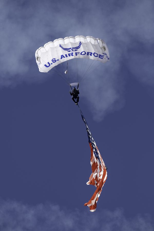 A United States Air Force Wings of Blue member parachutes into the opening ceremony of the Great Colorado Air Show at the Northern Colorado Regional Airport in Loveland Colorado presenting the American flag Oct. 17. (Garrett Mogel | The Collegian)