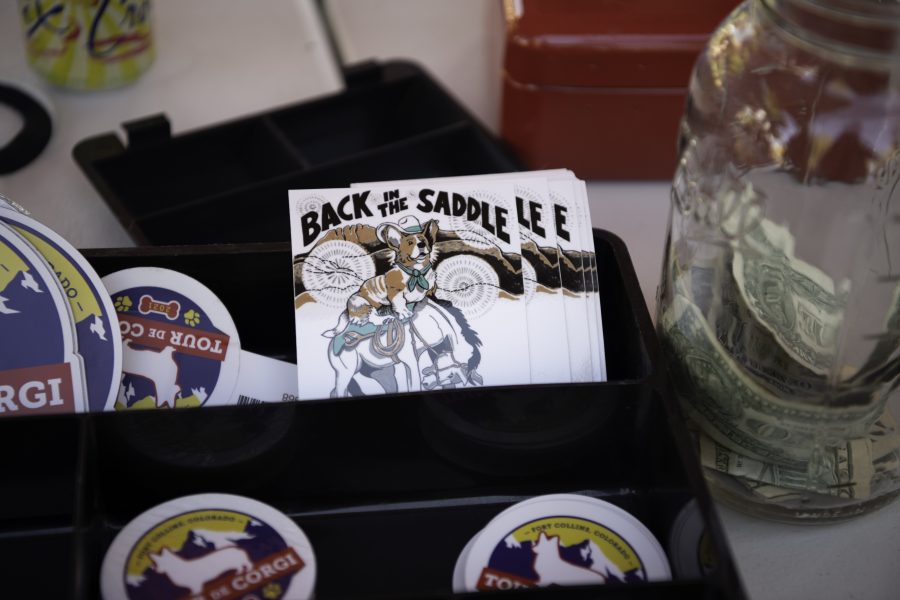 Stickers for sale at the entry to the seventh annual Tour De Corgi. The Tour De Corgi is a gathering and parade of Corgi’s beginning at the Civic Centre Park and parades through Old Town Fort Collins Colorado Oct. 2. (Garrett Mogel | The Collegian)