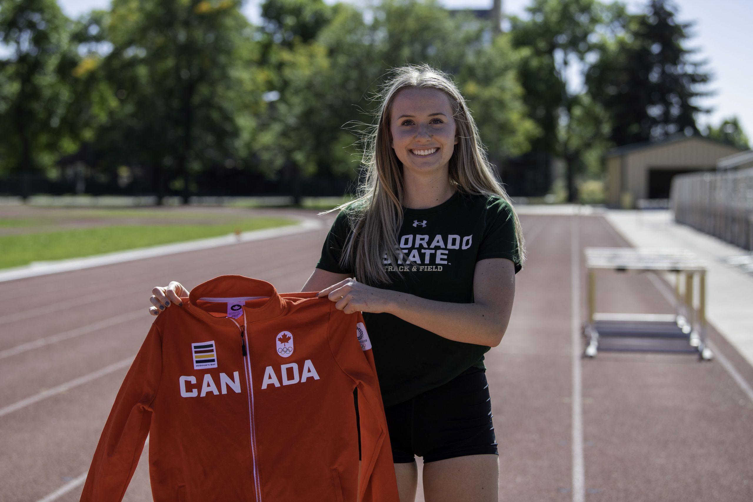 Lauren Gale holds up a jacket from the Canadian 2021 Tokyo Olympics 4x400-meter track team on the Jack Christiansen Memorial Track Fort Collins Colorado Oct. 4. (Garrett Mogel | The Collegian)