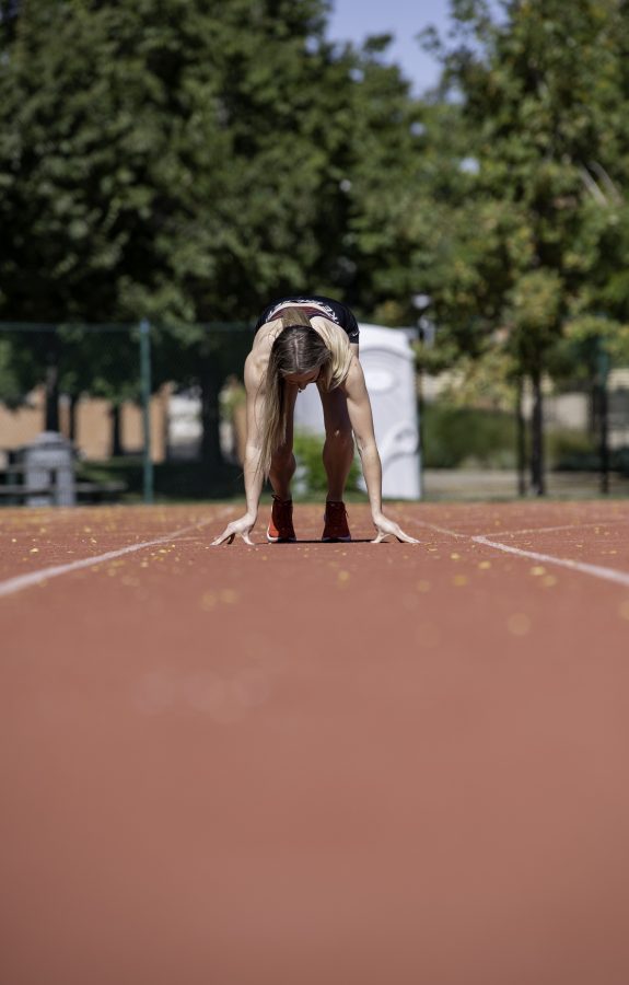 Lauren Gale in her 2021 Olympic jersey poses in a start position on the Jack Christiansen Memorial Track Fort Collins Colorado Oct. 4. (Garrett Mogel | The Collegian)