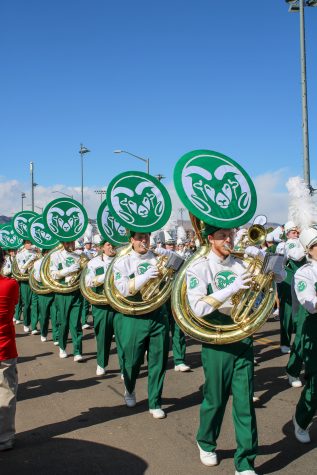 The CSU marching band leads the parade of poms dancers, cheerleaders, and football players into Canvas Stadium before the homecoming game. Photographer: Avery Coates