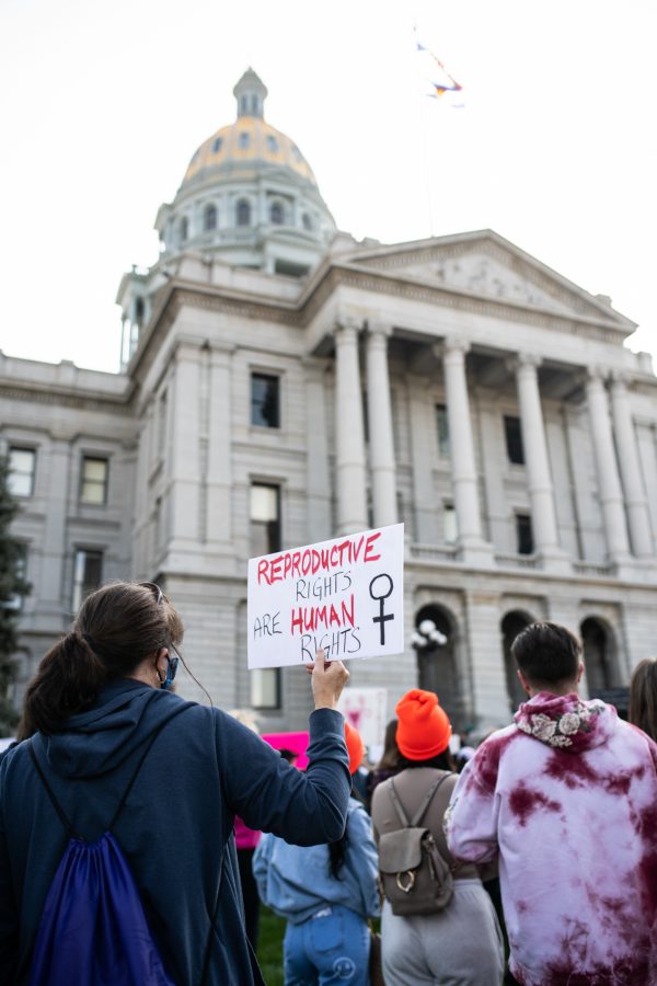 Early in the lineup of speakers, a march-goer holds a sign among the crowd of protesters at the Colorado State Capitol for the Women’s March in reaction to the restrictive abortion bill that went into effect in Texas last month, Oct. 2. (Lucy Morantz | The Collegian)