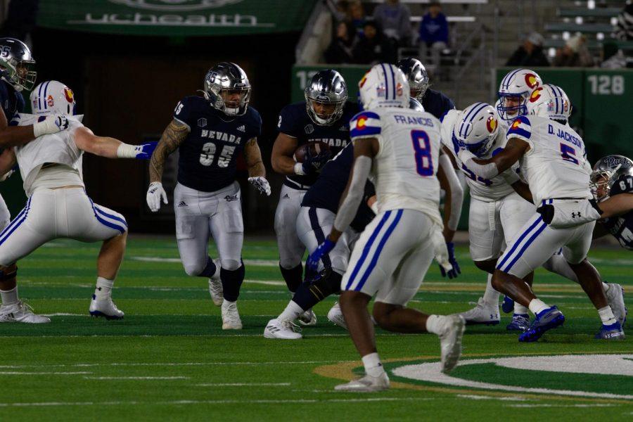 University of Nevada running back Devonte Lee (2) runs the ball upfield as Toa Taua (35) blocks Nov. 27.